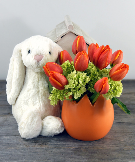 Bright Spring tulips and hydrangea bloom from a ceramic egg container. A cuddly soft plush rabbit. by Jelly Cat complete's your Spring classic look.