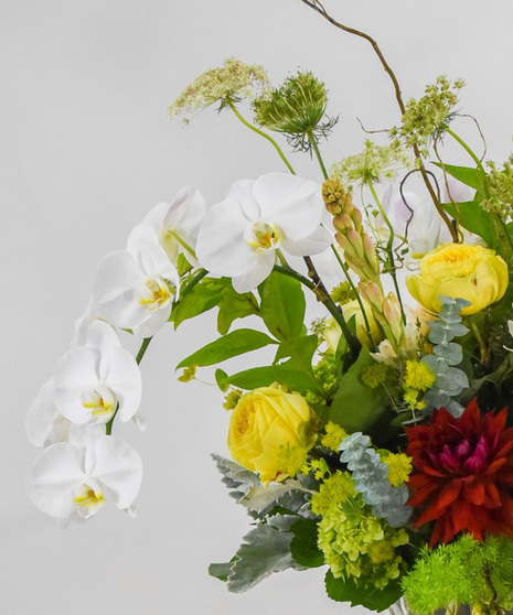 colorful example of floral arrangement that features orchids and roses