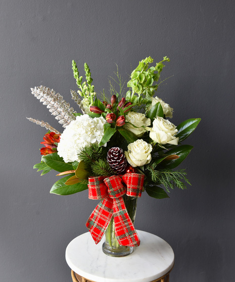 This arrangement is a classic beauty and modern flair of red and white, with roses,  snapdragons, alstroemeria, hydrangea,  bells of Ireland.  The Grand features an amarylis.