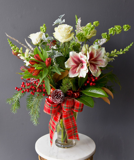 This arrangement is a classic beauty and modern flair of red and white, with roses,  snapdragons, alstroemeria, hydrangea,  bells of Ireland.  The Grand features an amarylis.