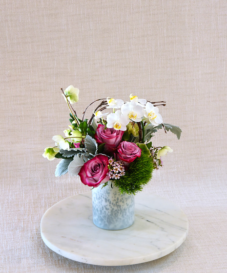 The I'm Yours  has mauve  roses,  pink carnations, orchids, gerrandos  and lush seasonal foliage.  The premium features calla lilies and tuberose. Designed in a glass vase