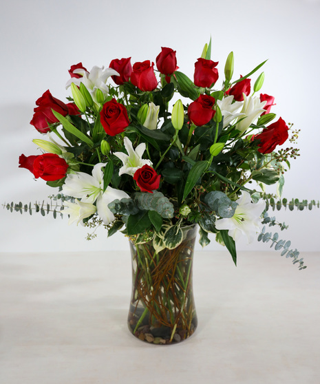 Premium Red Roses with fragrant liles and hydrangeas designed in a clear glass vase.  Upgrade to 24 roses