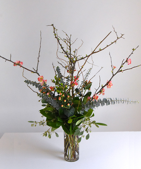 Quince blossoms in buds in vase arrangement