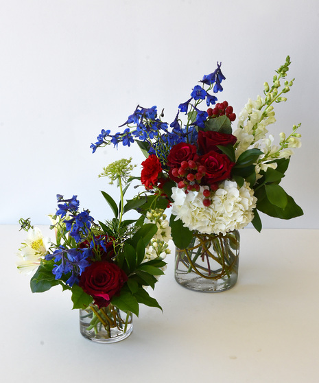 Two variation sizes of the Red, White & Bloom vase arrangements with USA flag.